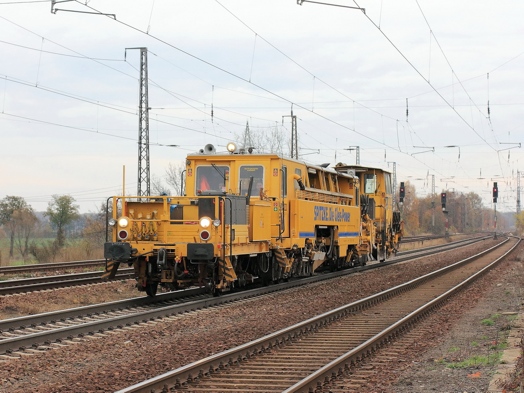 Gleisstopfmaschine 09-32 CSM der Firma Spitzke am 10. November 2012 bei der Durchfahrt durch den Bahnhof Saarmund. 