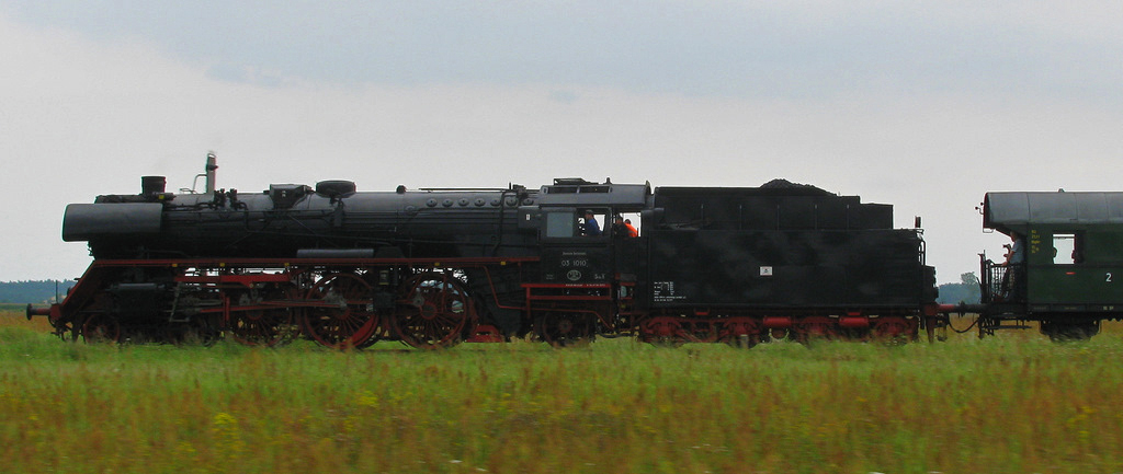 Gl�ck muss man(n) haben. Nach Wendisch Priborn wurde die Maschine wieder kurz vor Ganzlin eingeholt, bereits im Wald dampfte sie neben uns her. Also Kamera bereit gemacht, auf die Wiese gewartet und dann mit 80 gleichauf nebenher. So entstand diese volle Breitseite der 03 1010. 14.08.2011