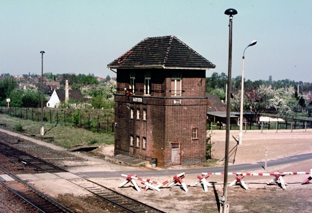 Grenzbahnhof Staaken 1975 das Stellwerk - Gelnde eingezunt, daneben der verminte Grenzstreifen, vorn Asphaltstrasse fr die Fahrten der Grenztruppen und Durchfahrsperren Richtung Mauer. Die Stellwerker hatten einen Sonderausweis und wurden 3x kontrolliert - vor der Arbeit und danach auch wieder. (bermittlung durch einen Stellwerker kurz nach der Grenzffnung).