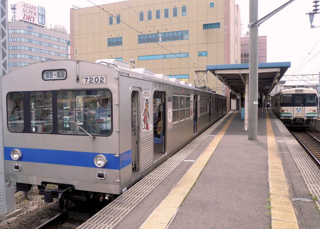 Grunddaten der Fukushima Verkehrsbetriebe (Schienenbetrieb): Die Verkehrsbetriebe der Stadt Fukushima im Nordosten von Japan betreiben eine 9,2 km lange Strecke (1067mm-Spur) nach Iizuka Onsen, berhmt fr seine heissen Quellen. Gefahren wird mit 4 Zweiwagen- und 2 Dreiwagenzgen, die 1991 vom Tky-Konzern (Tokyo S-Bahn) gebraucht bernommen wurden. Im Bild steht der Zweiwagenzug 7101-7202 im Bahnhof Fukushima; rechts daneben ein Zug der Abukuma-Bahn. 11.Juli 2010. 