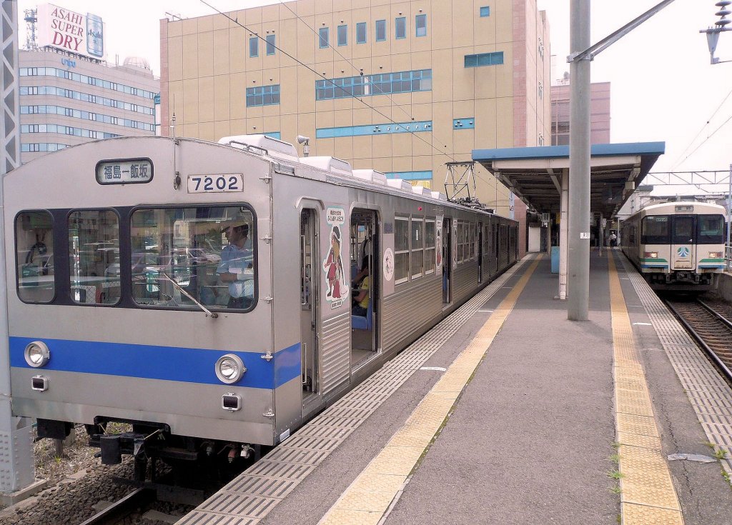 Grunddaten der Fukushima Verkehrsbetriebe (Schienenbetrieb): Die Verkehrsbetriebe der Stadt Fukushima im Nordosten von Japan betreiben eine 9,2 km lange Strecke (1067mm-Spur) nach Iizuka Onsen, berhmt fr seine heissen Quellen. Gefahren wird mit 4 Zweiwagen- und 2 Dreiwagenzgen, die 1991 vom Tky-Konzern (Tokyo S-Bahn) gebraucht bernommen wurden. Im Bild steht der Zweiwagenzug 7101-7202 im Bahnhof Fukushima; rechts daneben ein Zug der Abukuma-Bahn. 11.Juli 2010. 