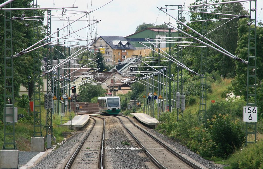 Haltepunkt Feilitzsch hinter Hof. Grade ist ein VBG Sprinterle nach Hof abgefahren und passiert hinten das links nach dem HP noch vorhandene alte Bahnhofsgebude des Ortes. Wie man sieht ist die Elektrifizierung hier schon fertig. Foto vom 13.07.2012.