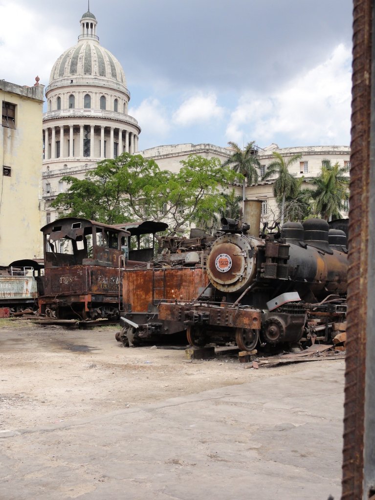 Havanna/Kuba. Mitten in der Stadt und fernab jeder Gleise (im Hintergrund das Capitol) stehen einige Dampfloks von div. Zuckerrohrbahnen und warten auf ihre Aufarbeitung fr ein Museum. Es gibt schon (recht versteckt) einige Fortschritte. Aufgenommen am 04.04.2011
