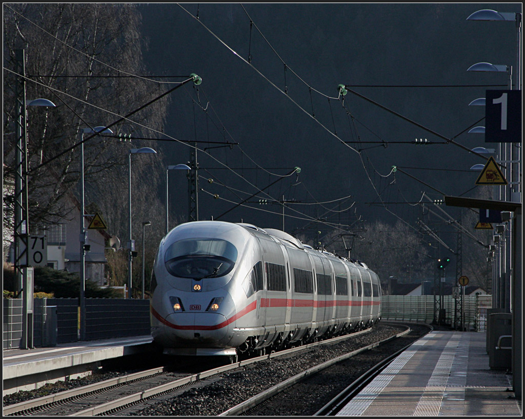 Heller Zug, dunkler Hintergrund - 

Ein ICE 3 bei der Durchfahrt des Haltepunktes Urspring auf der Schwäbischen Alb. 

03.01.2012 (M)