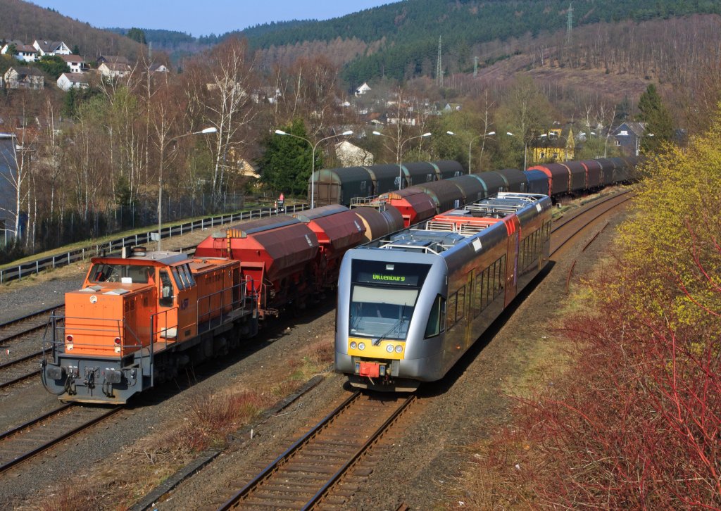 Herdorf am 29.03.2011: Links die Lok 41 der Kreisbahn Siegen-Wittgenstein (KSW) steht auf KSW eigenem Rangierbahnhof mit G�terzug zur �bergabefahrt bereit, rechts f�hrt ein Stadler GTW 2/6 der Hellertalbahn, auf dem DB-Gleis, Richtung Dillenburg.