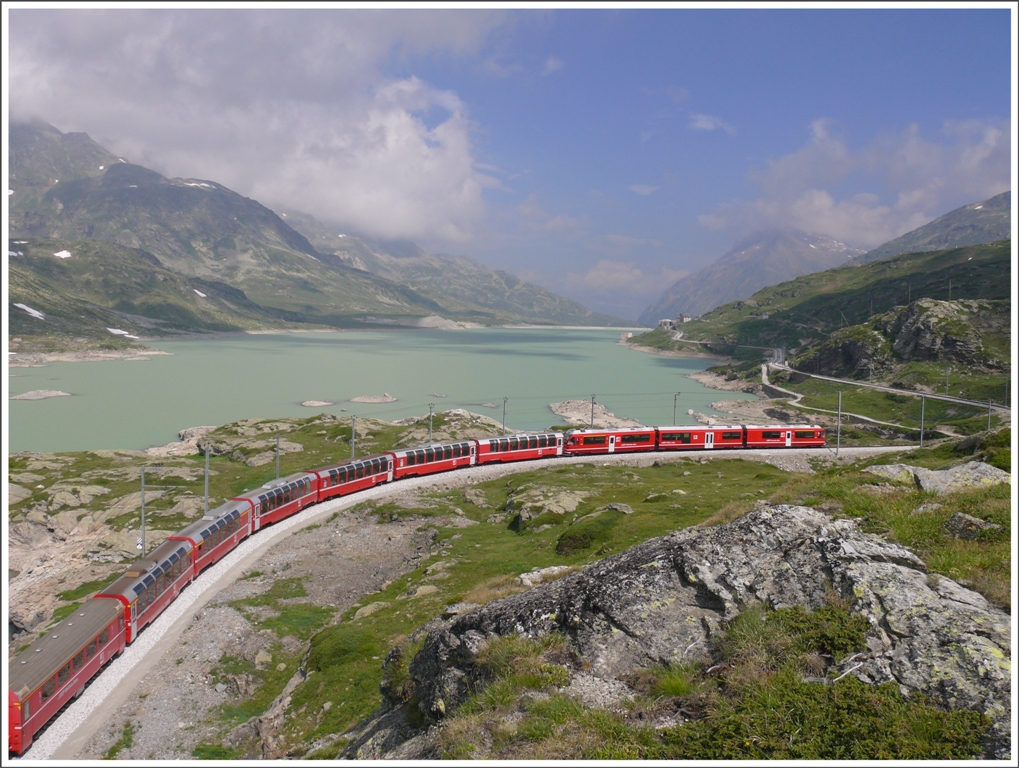 Herrliche Aussicht ber den Lago Bianco Richtung Norden. BerninaExpress 970 auf dem Weg von Tirano nach St.Moritz. Im Hintergrund rechts der Staumauer sind die Gebude von Ospizio Bernina auszumachen. Meine Wandertour: Ospizio Bernina-linkes Seeufer-hinauf nach Sassal Massone-zurck ber rechtes Seeufer- Lai Pitschen bis Bernina Lagalb. Inklusive diversen Fotohalten und Mittagspause auf Sassal Massone 7Std. Zum Nachahmen empfohlen. (14.07.2010)