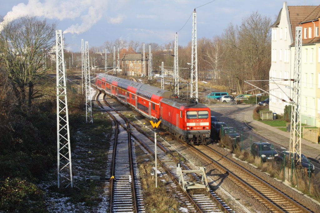 Heute zieht die 114 034 den RE4 von Wismar nach Ludwigslust. Aufgenommen bei der Ausfahrt aus dem Bf. Wismar. 15.12.2009