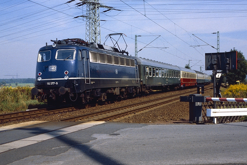 Hier ist die 110 377-9 Anfang der 80iger Jahre mit einem Schnellzug zwischen Soest und Unna unterwegs.   