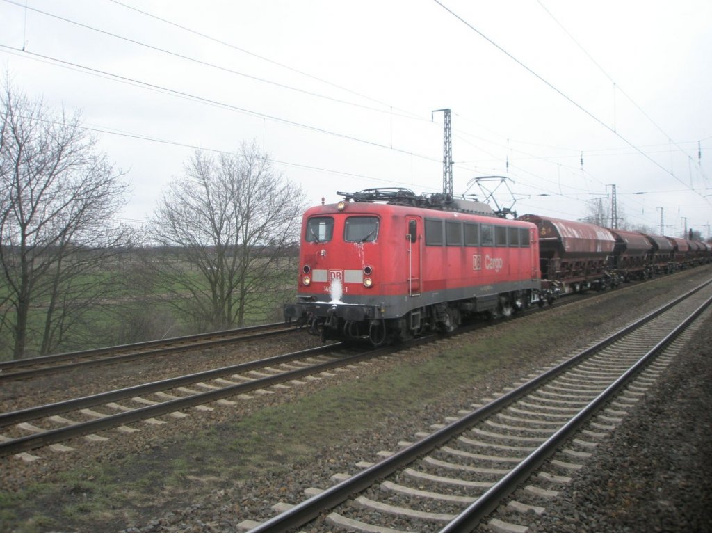 Hier 140 401-1 mit einem Schttgutwagenzug in Richtung Seddin, bei der Durchfahrt am 6.3.2010 durch Saarmund.