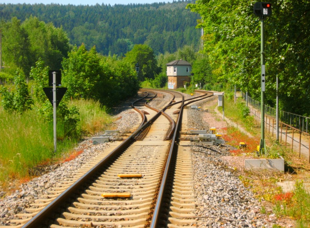 Hier ist die Bahnhofseinfahrt von Zella-Mehlis aus Richtung Oberhof zu sehen.
Die beiden linken Gleise sind die Hauptstrecke Richtung Meiningen.Hier fahren 612er der DB als RE und Regioshuttles der STB als RB ,das rechte Gleis ist die Nebenbahn Richtung Wernshausen und wird ausschliesslich von Regioshuttles der STB befahren. Jedes Jahr im Februar ist auf der Nebenbahn der Rodelblitz unterwegs. Er wird bespannt mit einer Dampflok der BR 41 (41 1144).
Im Bahnhof Zella-Mehlis kommt es dadurch �fter mal zu Zugkreuzungen von Haupt- und Nebenbahn. Die Umsteigem�glichkeiten von Haupt- auf Nebenbahn sowie die relativ kurzen Wartenzeiten sind erfreulich (manchmal kann man auch direkt umsteigen). Kompliment an die STB.
Die Aufnahme habe ich am 5.6.11 vom Bahn�bergang aus gemacht.
