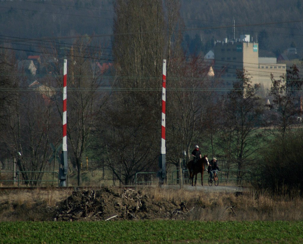 Hier ist  dem Fotografen das Motiv nicht weggeglitten , sondern ist weggeritten.  So musste das Tele ran , aber leider ist die Qualit�t  nicht  �berzeugend so da� die Reiterin wohl kaum eine Chance  hat , bei den Bahnbildern
gespeichert zu werden, es ist der Bahn�bergang, dessen �ffnung per Tastendruck angefordert wird.