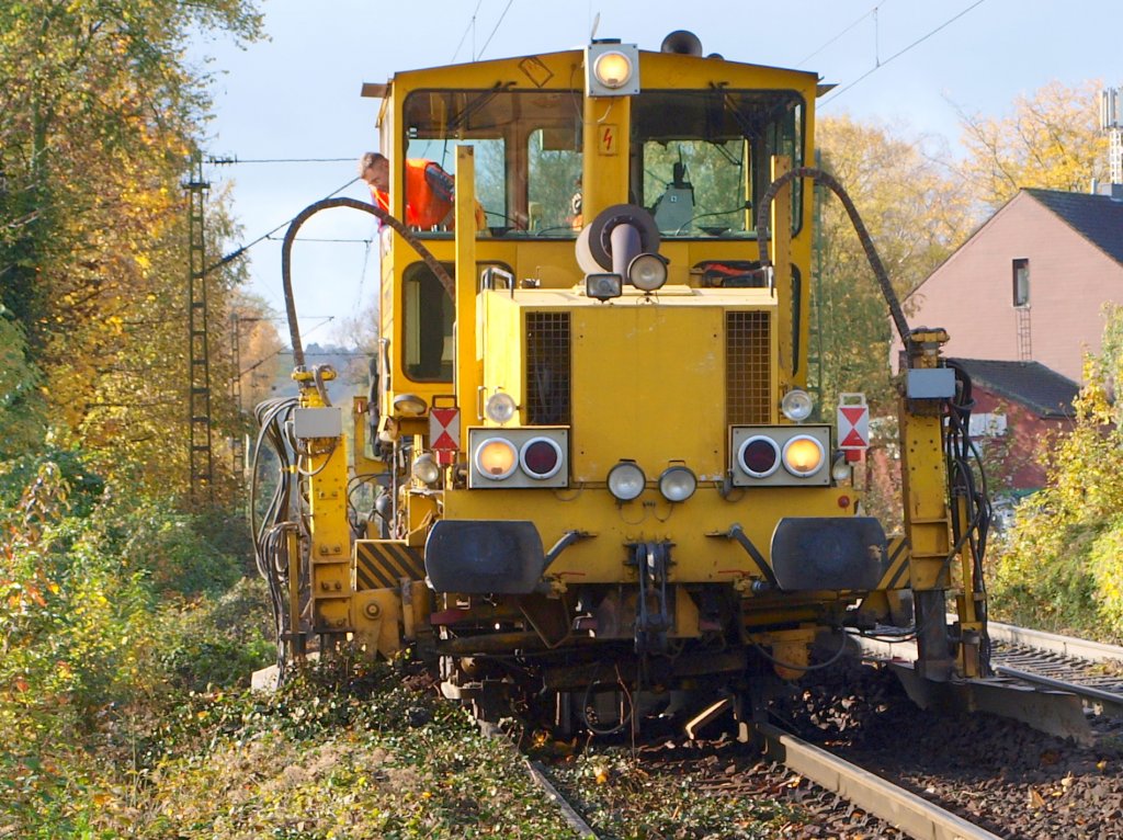 Hier wird mit einem Schotterpflug das Gleisbett auf der Talstrecke der Montzenroute in Aachen profiliert nachdem mit einer Stopfmaschine das Gleis neu gestopft wurde. Da hier die schweren Gterzge von Belgien bergab abgebremst werden war das Gleis uneben und das Gleisbett vom Bremsstaub und Dreck verdichtet. Und wie man sehen kann erobert die Vegetation neben der Strecke auch das Gleisbett.
