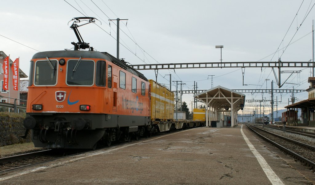 Hier zeigt erst der Nachschuss das Besondere: Schiebende und vom ex Cargo Sprinter ferngesteuerte Re 4/4 II 11320 auf der Fahrt von Felsberg nach Daillens bei der Durchfahrt in Chavornay am 1. Februar 2010 