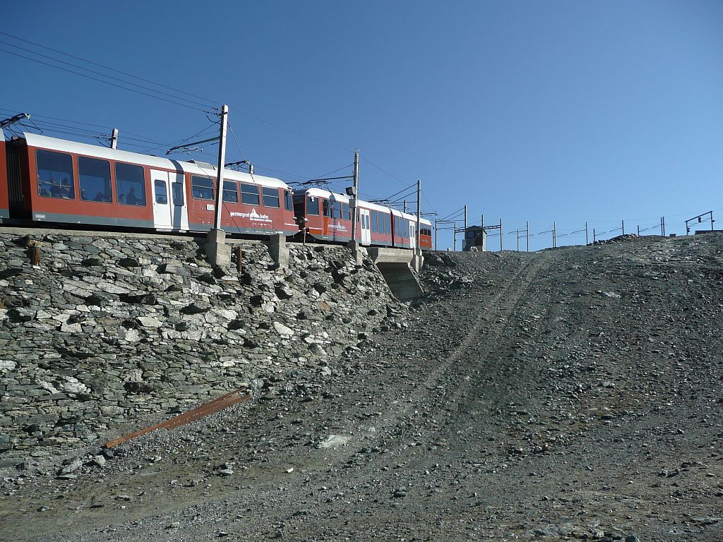 Himmelwrts! Das bereits  zuvor aufgenommene Bhe 4/6-Doppel nhert sich auf den letzten Metern bis zur Bergstation Gornergrat dem Weichenwrterhuschen bei der Einfahrt. Whrend die Aussicht am 1.8.2011 grandios ist, prsentiert sich der Gornergrat selbst als Gerllhalde. 