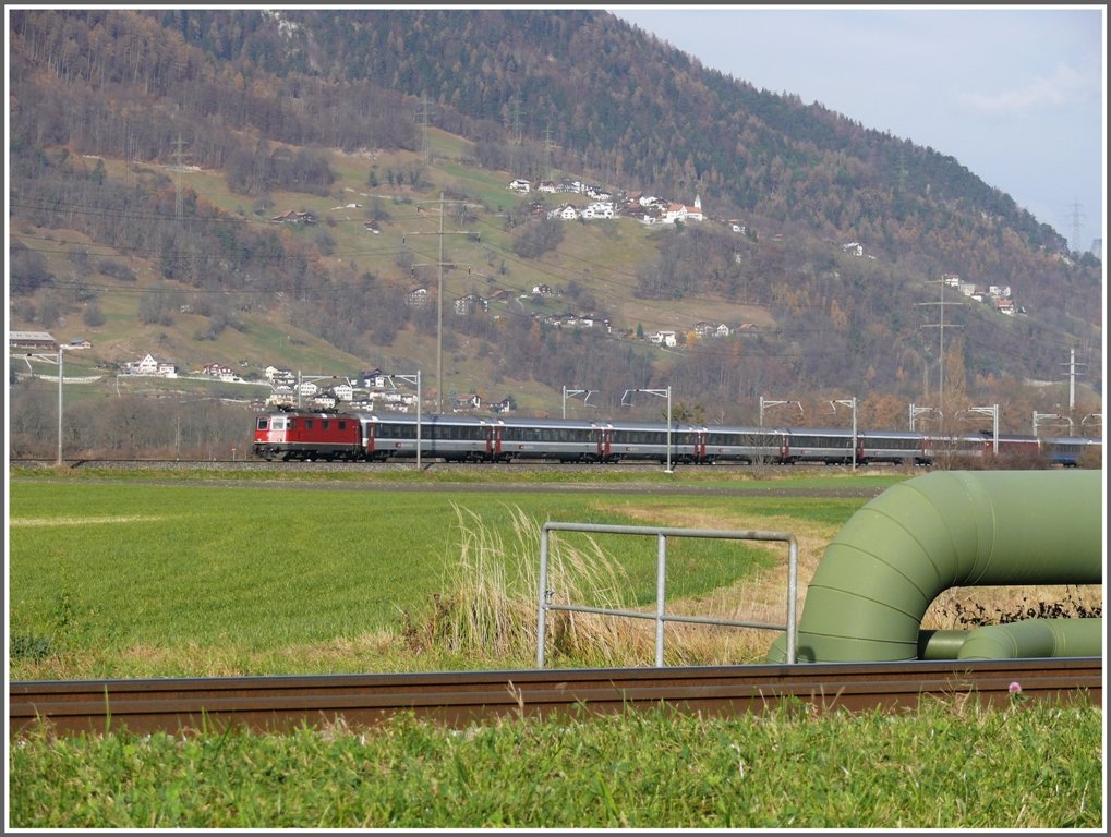 Hinter dem RhB Geleise Zizers - Igis und der Fernwrmeleitung KVA Trimmis - Papierfabrik Landquart verluft die SBB Doppelspur Landquart - Chur. IR 1765 mit Re 4/4 II passiert soeben die Ebene unterhalb der Kirche Mastrils. (22.11.2009)