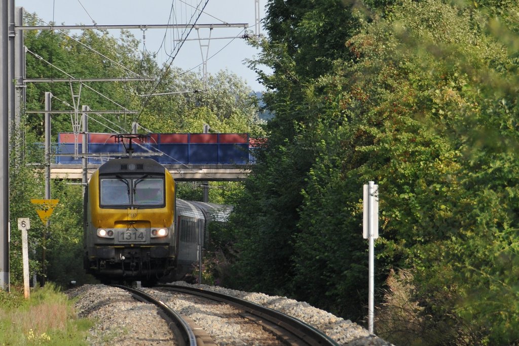 HLE 1314 befindet sich hier mit ihrem IC A Eupen - Oostende auf dem kurvigen eingleisigen Stck zwischen Eupen und Herbesthal in der Steigung bei Gemehret. Die Aufnahme entstand am 11/08/2011 vom Bahnbergang Gemehret.