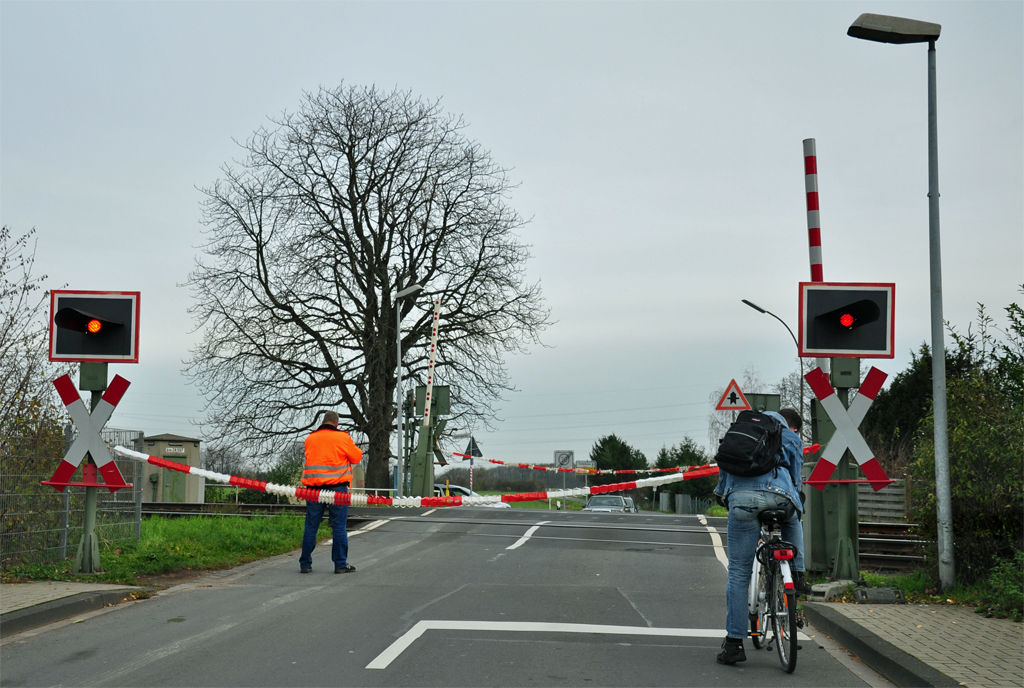  Hochsicheheitsbahnbergang  bei Euskirchen. Abgesichert mit:
1) Warnblinkanlage
2) Posten mit Sicherheitsweste
3) Schranken (sind o.k. und schlieen gleich) und
4) schne rotweie  Girlanden . 
Euskirchen 15.11.2010