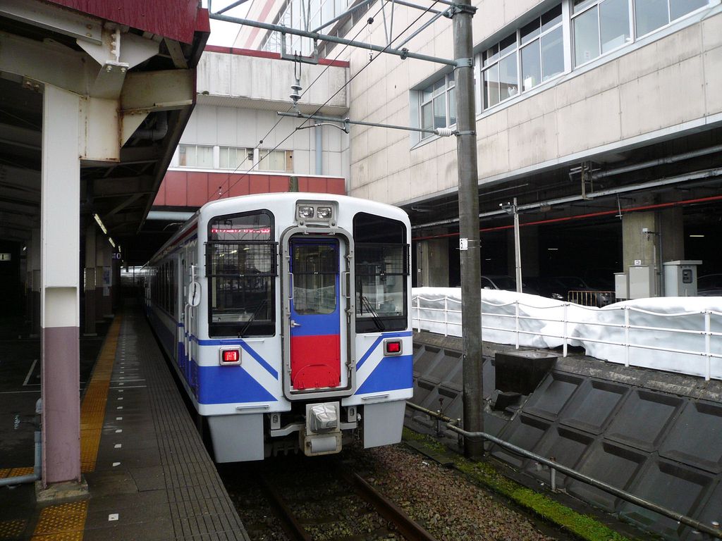 Hokuetsu Express Lokalzge: Fr diese Dienste wurden 1997-2003 12 Wagen beschafft, die Einzelwagen 1 bis 10, und ein Zweiwagenzug 101+102. Im Bild steht Wagen Nr.2 in der schneereichen Ausgangsstation Echigo Yuzawa, im  Loch  unter den erdrckenden Bauten des Shinkansen. 28.Februar 2010.