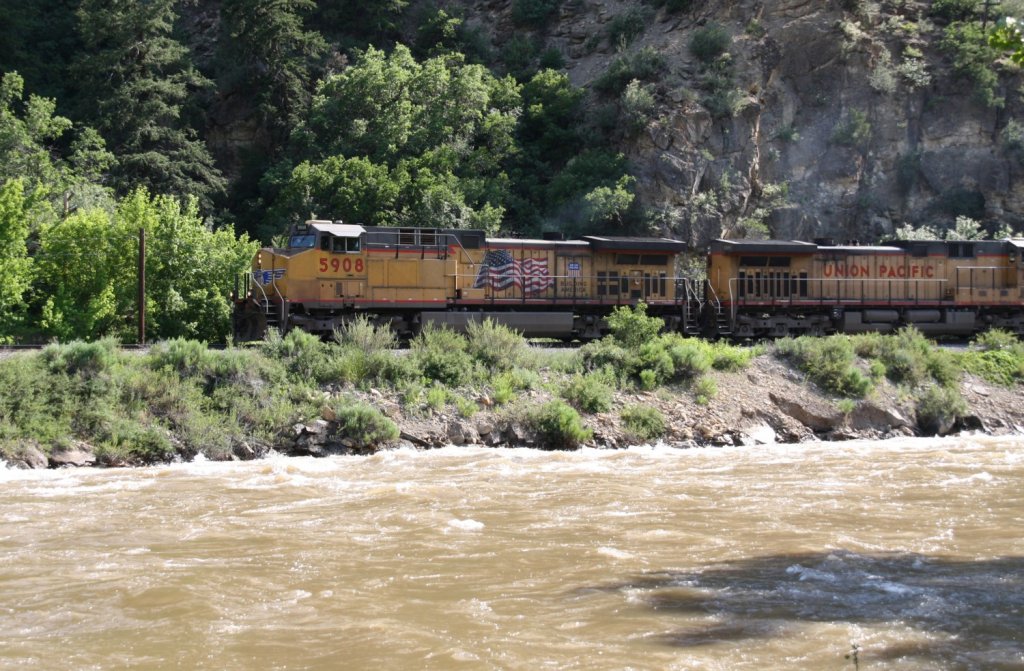 I. - 29.6.2011. 3km stlich von Glenwood Springs, CO. Union Pacific 5908 + 7293 vor einem Kohlezug Richtung Denver als erste Loks. Der Colorado fhrt Hochwasser. Angaben zum Loktyp willkommen.