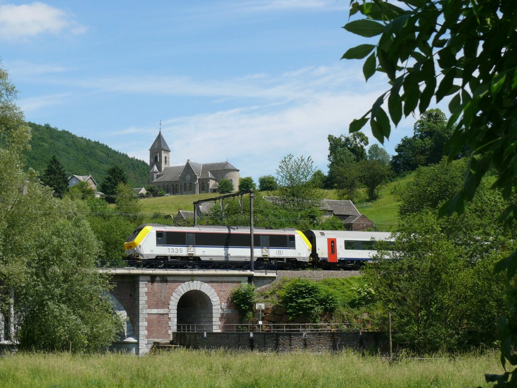 IC A Eupen - Oostende mit Lok 1335 auf der Fahrt durch das malerische Wesertal, hier aufgenommen auf einer Brcke bei Goffontaine. Im Hintergrund auf dem Hgel erkennt man die Eglise Saint Monon von Goffontaine. Dieser Heilige lebte als Eremit in den belgischen Ardennen bei Nassogne, und wurde 645 von Bewohnern eines Nachbardorfes enthauptet, nachdem er deren Steingtzen zerstrt hatte. Das Bild entstand am 13/06/2010. 