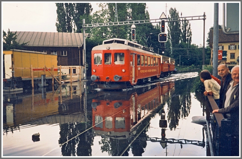 Ich habe noch ein paar Archivfotos ausgegraben (gescannte Fotos). ABDeh 2/4 24 mit zwei Sommerwagen im Juli 1987 erreicht in K�rze Rorschach Hafen. Wegen des Hochwassers kriegte auch die RHB nasse  F�sse . (07/87)