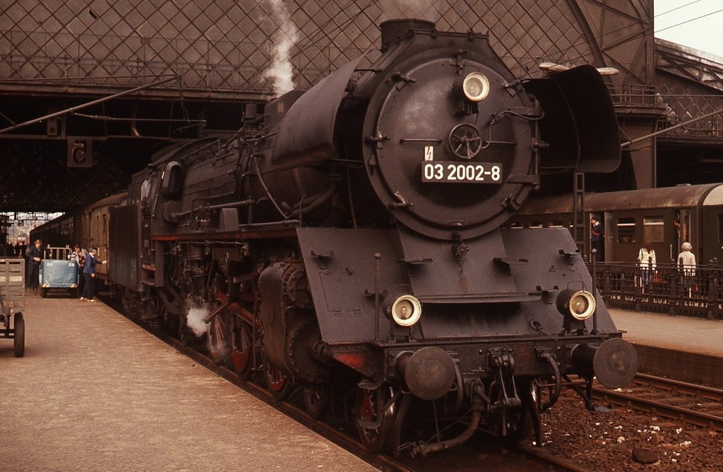 Im August 1977 hat 03 2002-0 mit ihrem Personenzug im Bahnhof Dresden-Neustadt das größte Stück ihres Weges von Görlitz bereits zurückgelegt und wird nach einem kurzen Zwischenhalt ihr Ziel Dresden Hauptbahnhof wenige Minuten später erreichen.