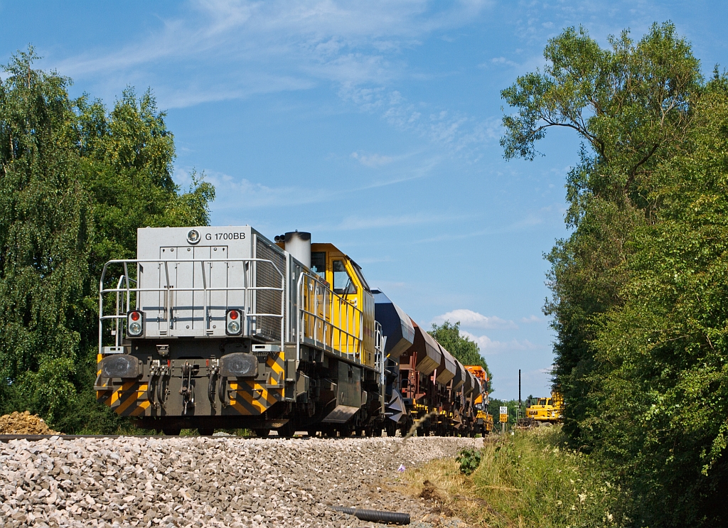 Im Bauzugdienst....

Die 277 031-1 (MaK G 1700 BB-2) der Schweerbau (bzw. eingestellt bei LDS) mit 6 Schotterwagen und hinten ein Kanalsplwagen auf einem Niederbordwagen, hier am 17.07.2013 in Wrgendorf, beim B km 105,2 der KBS 462 (Hellertalbahn).

Die MaK G 1700-2 BB wurde 2011 unter der Fabriknummer 5001870  bei Vossloh in Kiel gebaut, sie hat die komplette NVR-Nr. 92 80 1277 031-1 D-LDS (eingestellt bei LDS).