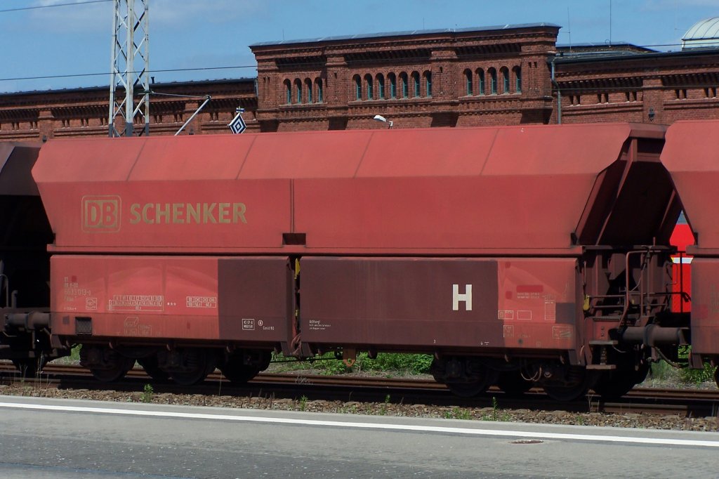 Im gleichen Erzzug waren neben vielen Falns 183.1 auch einige Falns 181 eingestellt. Diese trugen einen roten Anstrich und die Aufschrift DB Schenker, dieser hier hate aber schon Farbausbesserungen in Braun erhalten. Aufgenommen in Wittenberge vor dem Hintergrund des dortigen Ausbesserungswerkes am 6.7.13. 