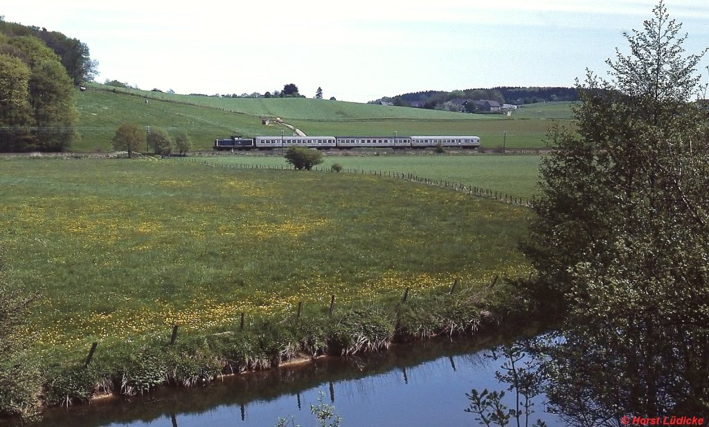 Im Mai 1986 befördert eine 212 bei Hämmern einen Nahverkehrszug von Wipperfürth nach Remscheid-Lennep. Im Vordergrund die Wupper, die hier noch Wipper heißt. Ende des selben Monats wurde der Personenverkehr eingestellt.