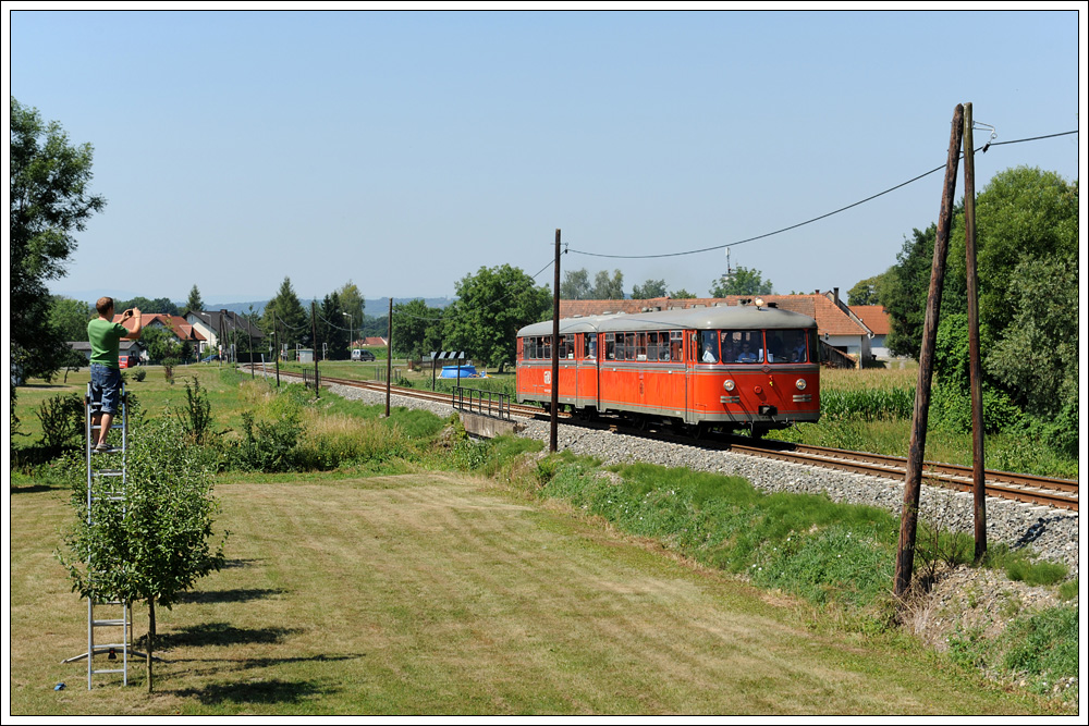 Im Normalfall strt ja eine fremde Person am Bild, hier finde ich sie aber ganz witzig. VT 10.02 + VB 10.12 als R 19679 von Graz nach Bad Radkersburg anlsslich der Feierlichkeiten 125 Jahre Radkersburger Bahn am 11.7.2010 kurz nach Purkla.