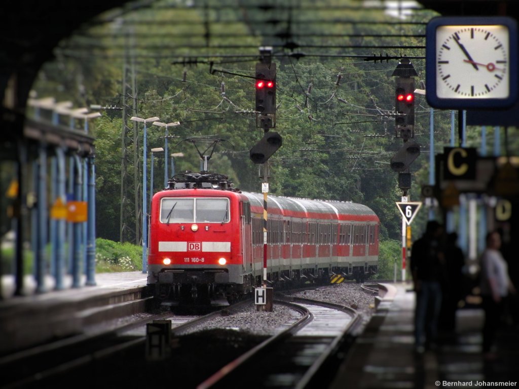 Im Regen fhrt 111 160-8 als Ersatz fr zwei ET 425 mit der RB48 in die Bonner Bahnhofshalle ein. August 2011