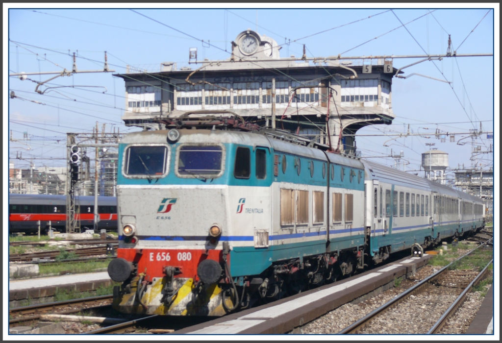 Im Regionalzug von Milano nach Lecce. 1.Tag 
Ein IC mit der betagten E 656 080 passiert eines der ehemaligen, markanten Stellwerke in Milano Centrale. (05.04.2011)