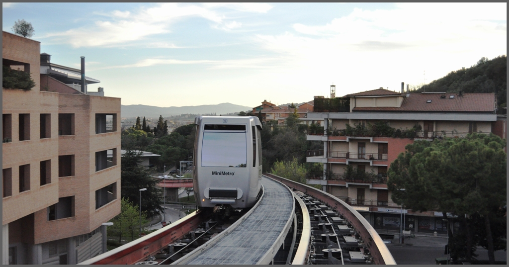 Im Regionalzug von Milano nach Lecce. 2.Tag (06.04.2011)Perugia 
Zum Ein- und Ausstieg in den Zwischenstationen werden die Kabinen vom Seil abgekuppelt und mit seitliche Pneurollen weiterbewegt. An den Endstationen werden die Wagen auf einer Drehscheibe!! gedreht und das Ganze vollautomatisch.