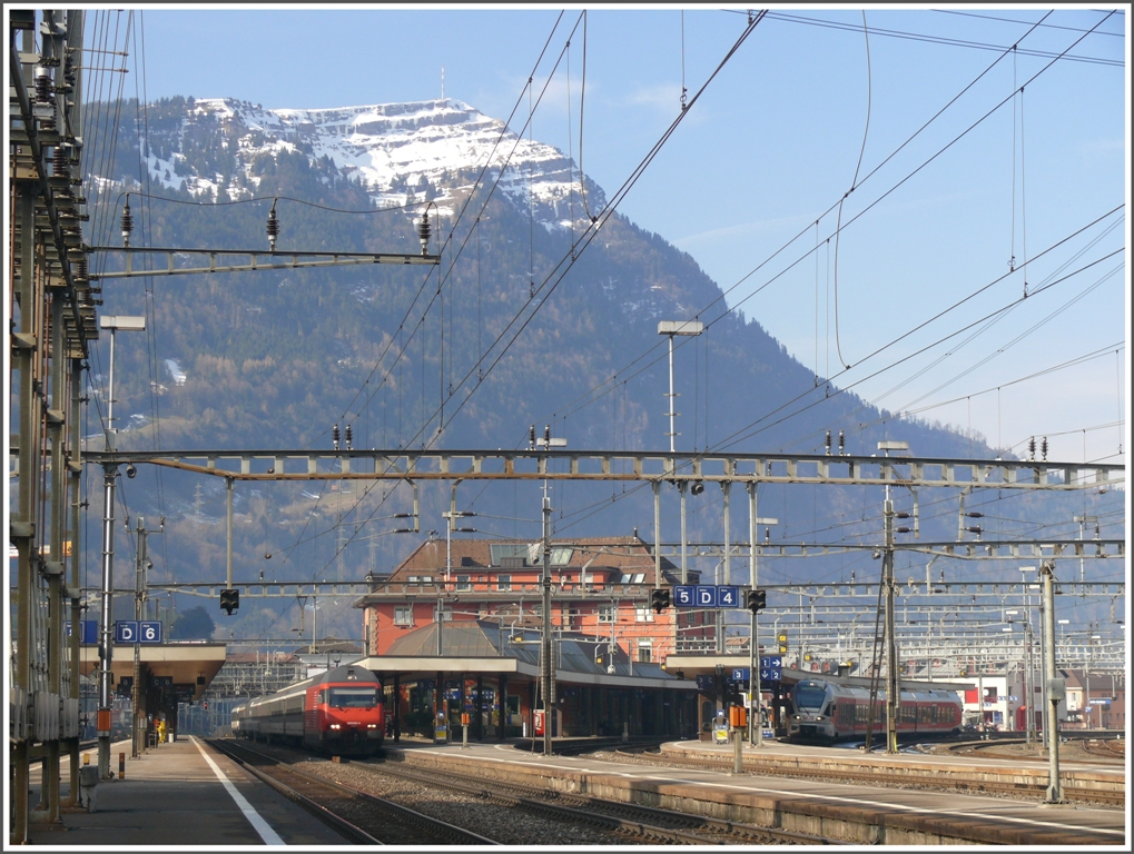 Im Schnittpunkt der Luzerner und Zrcher Linie liegt der Bahnhof Arth-Goldau. Darber thront die Knigin der Berge, wie die Rigi 1800m auch genannt wird. Auf Gleis 5 (Luzerner Seite) steht IR2169 mit Re 460 066-4 und auf Gleis 2 (Zrcher Ast) ein Flirt der SOB nach Biberbrugg. (14.02.2011)