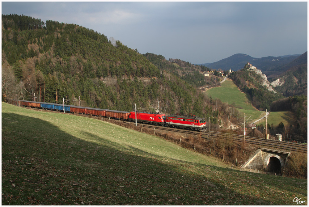 Im sogenannten Blauen Einschnitt, fahren 1142 654 und 1116 254 mit einem Schrottzug.Im Hintergrund ist gut die Burgruine Klamm zu erkennen.
Klamm 24.3.2012