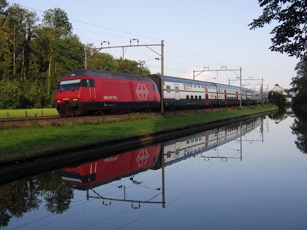 Im Wasser des Thurkanals bei Brglen (TG) spiegelt sich am 10.08.2012 Re 460 052-4 mit den Wagen des IC 840 von Romanshorn nach Bern