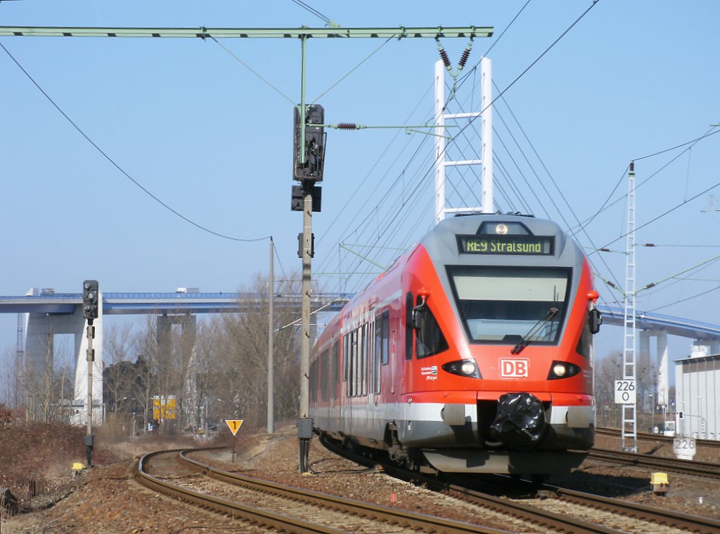 Immer wieder ergibt die Rgenbrcke ein schnes Motiv,wenn ein Zug an der imposanten Brcke vorbei fhrt,so auch am 22.Mrz 2011 als RE 13028 Binz-Stralsund,gefahren von 429 030,den Bahnhof Stralsund Rgendamm verlie.Links das Zufahrtsgleis zum Stralsund Nord-und Sdhafen.  