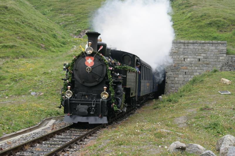 In 28 Jahren freiwillige Arbeit wurde die Furka Bergstrecke wieder durchgehend aufgebaut. Es ist nicht grad der gerechte Lohn dass es am Wochenende der feierlichen Erffnung stark geregnet hat. Der durchgehende Zug von Realp nach Oberwald hat das Wallis erreicht und fhrt nun das Rhonetal steil hinab ber Gletsch nach Oberwald; 14.08.2010