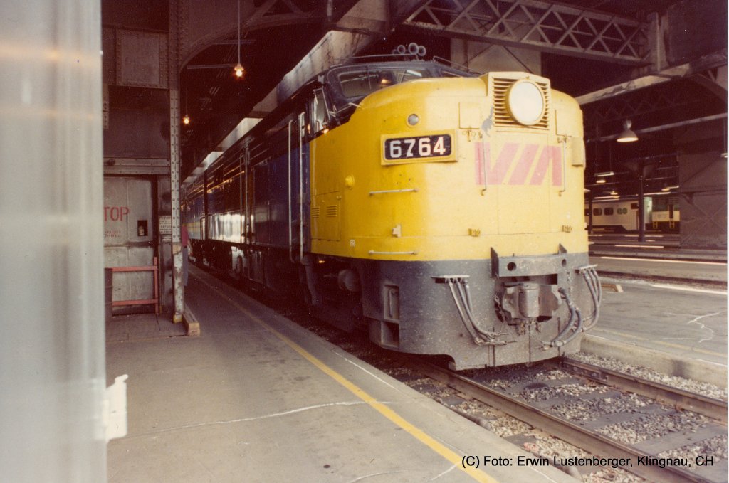 In die Bahnhofhalle von Toronto (ON) einfahrende 6764 zusammen mit einer zweiten Maschine (A- oder B-Unit ist leider nicht ersichtlich). Die Loks werden an den Reisezug mit Bestimmung Montral (QC) angehngt. Die Fahrt fr diese Strecke dauert zirka fnf Stunden und es ist eine Distanz von 539 km zurck zu legen. Es ist eine nach CN (Canadien National) Class bezeichnete MPA-18b (M = Montreal Locomotive Works oder American Locomotive Works (Alco), P = Personenverkehr, A = mit Fhrerstand (A-Unit), 18 = 1'800 PS, b = Unterklasse (es gab a, b, c) bzw. Erbauertyp FPA-4 von Alco (American Locomotive Company). Die Lok wiegt 116t und hat vier Achsen. Pro Achse sind dies 29t was fr Europa viel zu schwer wre. Baujahr 1955 bis 1959. Die 1.800 PS (1.300 kW) der FPA-4/FPB-4 wurden durch einen 251V-12-Motor erreicht. Erbaut wurden die Loks durch die kanadische Tochtergesellschaft ALCO's, Montreal Locomotive Works (MLW). Aufnahme vom 13.07.1981. Aufnahmedatum: 13.07.1981.