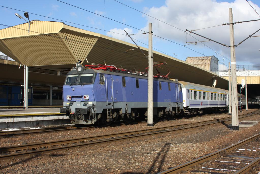 In einem lila Farbenkleid steht EP 09-08 vor einem Schnellzug
abfahrbereit im Bahnhof Krakow Glowny am 15.2.2008.