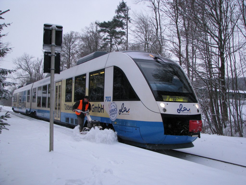 In Gadebusch an der Strecke Rehna - Schwerin - Parchim steht Tw 703 der OLA nach Parchim bereit. Im Vordergrund wird gerade der Bahnsteig vom Schnee berumt.