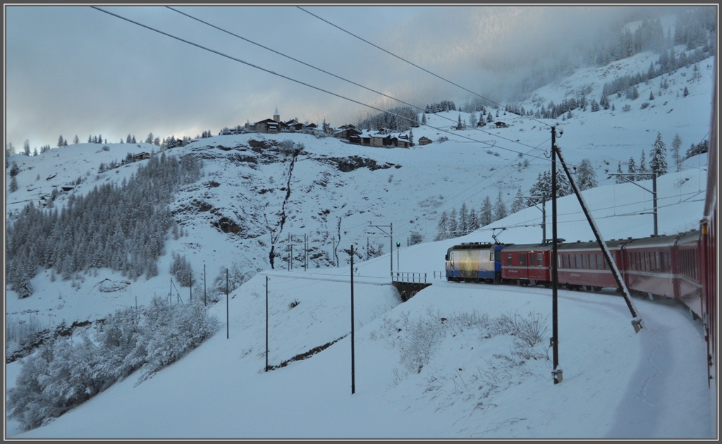 In den Kehren oberhalb Bergn schraubt sich RE1121 in die Hhe. Das Dorf auf der Anhhe heisst Latsch. (08.12.2011)
