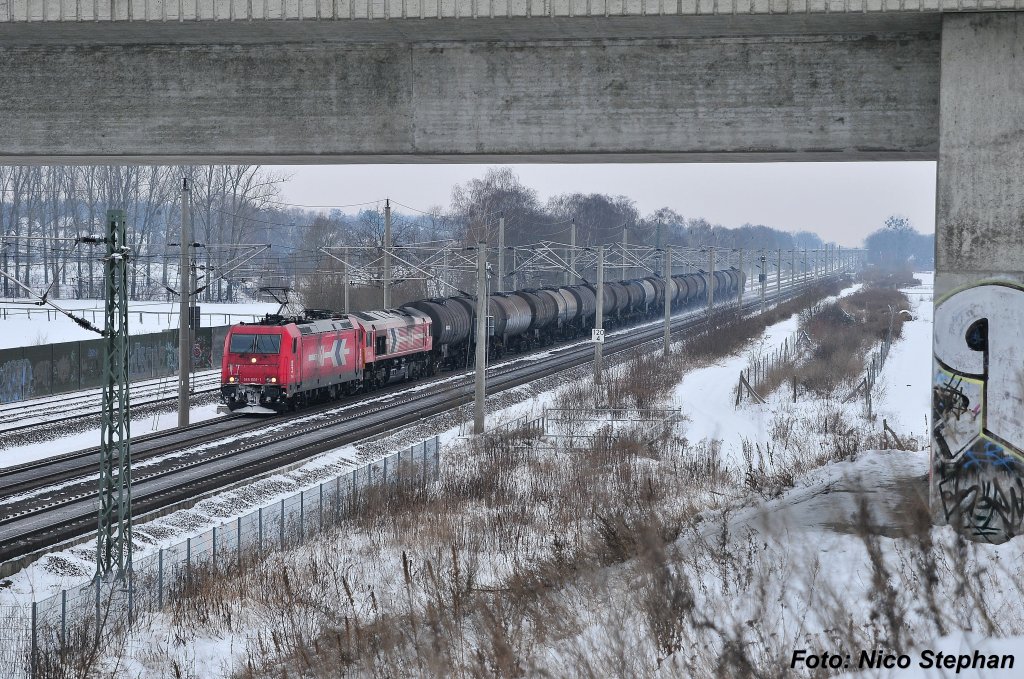 In migem Tempo rollen die zu HGK gehrenden 185 606-1 & DE 670 samt Kesselzug der Stadtgrenze Berlins entgegen und passieren hier eine der unzhligen Brcken ber die Schnellfahrstrecke Berlin - Hannover,bei Dallgow-Dberitz am 05.01.10