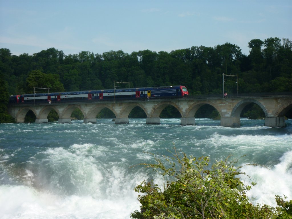In der Mitte des Rheinfalls ist ein Felsen mit einer Aussichtsplattform von dem man den Bahnverkehr zwischen Schaffhausen und Zrich beobachten kann. Hier berquert am 29.6.2010 eine Re 450 die Rheinbrcke.
