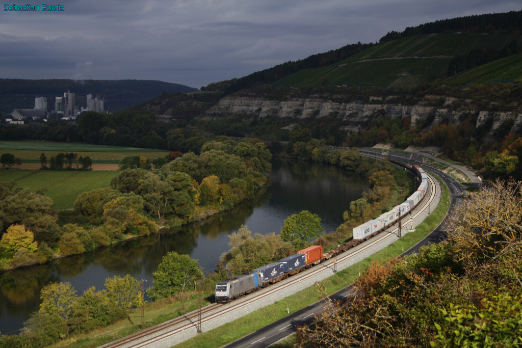 In der Morgensonne des 3. Oktober 2012 ist eine 185 von Railpool mit einem Containerzug im Maintal unterwegs, hier zwischen Karlstadt und Himmelstadt