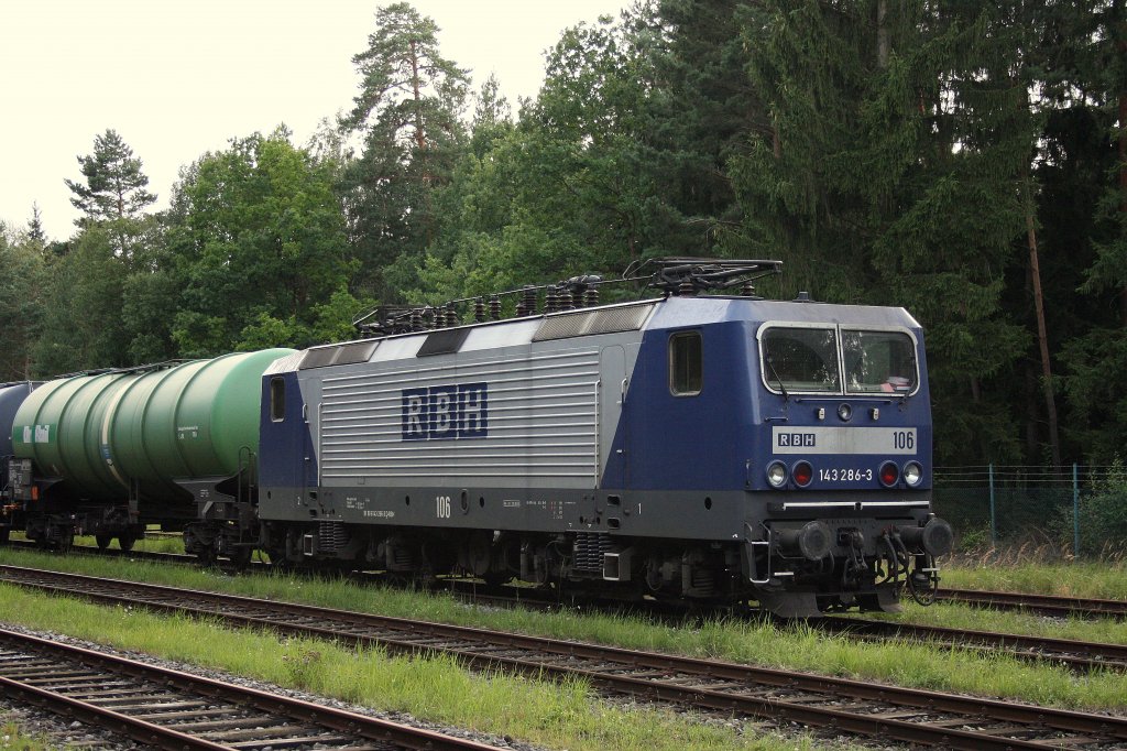 In Mnchen - Freiham Tanklager war am 14.08.2011 die 143 286-3 der RBH zu sehen. Foto entstand vom nahegelegenen, ffentlichen Spazierweg durch den Wald. 