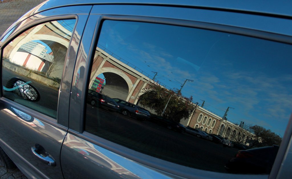 In den Seitenscheiben meines Pkw spiegelt sich am 18.11.2011 das Burtscheider Viadukt in Aachen. Das 277 Meter lange und bis zu 17 Meter hohe Viadukt wurde 1838-1840 als erstes deutsches Eisenbahnviadukt durch die Rheinische Eisenbahn aus Backsteinen gebaut und verbindet den Hbf mit Aachen Rothe Erde (KBS 480). Am 16.04.1944 wurde der letzte Bogen vor dem Hbf von einem nationalsozialistischen Kommando gesprengt um den Alliierten, die immer n�her an den Westwall bei Aachen r�ckten, nicht die wichtige Eisenbahnlinie zu �berlassen. Der zerst�rte Bogen wurde nach dem Krieg durch eine eiserne Br�cke ersetzt. Die 24 Viaduktb�gen des denkmalgesch�tzten Bauwerks wurde in den Jahren 2007–2009 durch eine neue Stahlbetonschalenkonstruktion verst�rkt.
