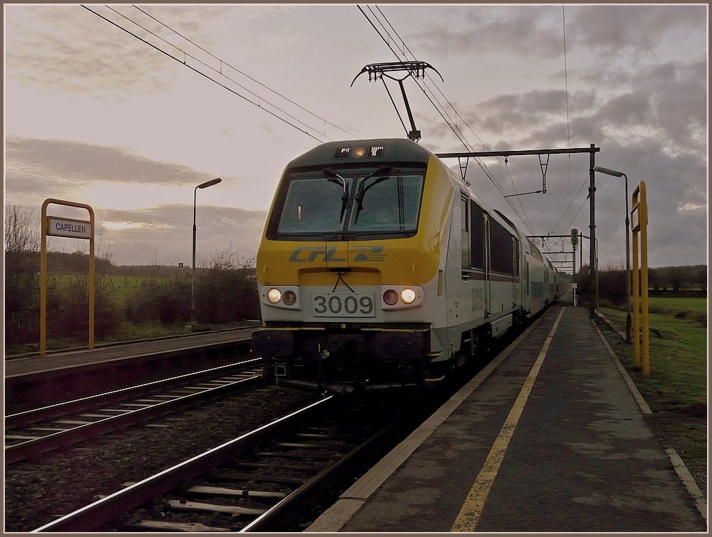 In der sonderbaren Abendlichtstimmung des 15.11.09 fhrt die 3009 mit ihren DoStos durch den Bahnhof von Capellen. (Jeanny)