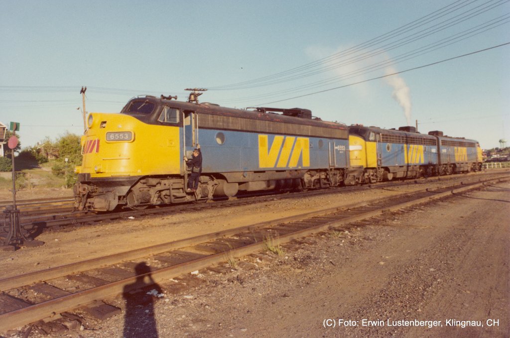In Sudbury (ON) wird die Lok 6553 als Verstrkung beigestellt. Es ist eine GPA-17f (Bezeichnung nach der VIA-Rail Klasse). In der Mitte befindet sich die Lok 1402 es ist eine DPA-15a welche den Wasserboiler aufgeheizt hat. Dies ist bei diesem Zug noch erforderlich da die Wagen noch mit Dampf beheizt werden. Im Bild am Schluss befindet sich die Lok 1418 der VIA-Rail Klasse DPA-15b. Die ersten beiden Loks haben Baujahr 1953 die letzte Baujahr 1952. Erklrung zur Bezeichnung: G = General Motors Diesel Division (ex CN), D = Diesel (ex CP), P = Personenverkehr, A = mit Fhrerstand (A-Unit), 15 = 1'500 PS, 17 = 1'700 PS, a, b, f = Unterklasse. Aufnahme vom 15.07.1981. Aufnahmedatum: 15.07.1981.