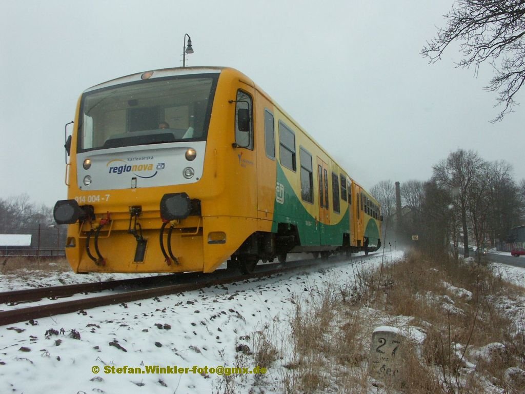 In Tschechien bzw. Nordbhmen ganz nahe der deutschen Grenze ist Asch. Diese Strecke war frher wichtige eingleisige Hauptbahn. Grenzberschreitende Gterzge gab es noch bis 1998. Jetzt ist die Verbindung nach Deutschland gekappt. An frhere Zeiten erinnert noch nahe des Ortes ein wohl restaurierter Kilometerstein (27 von Eger) der hier grade am 17.12.2009 von einem Regionova-TW Reihe 814 passiert wird.